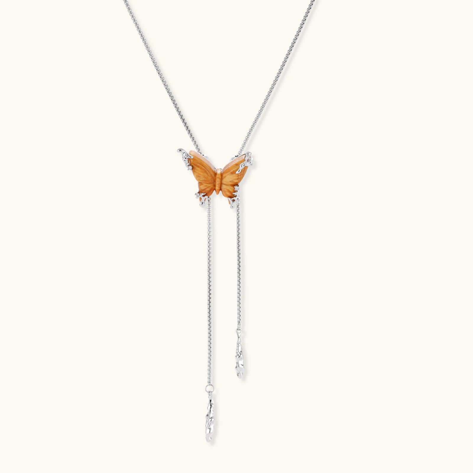 Wooden butterfly pendant necklace with cascading silver-toned chains on adjustable chain, available in amber and black.