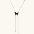 Wooden butterfly pendant necklace with cascading silver-toned chains on adjustable chain, available in amber and black.